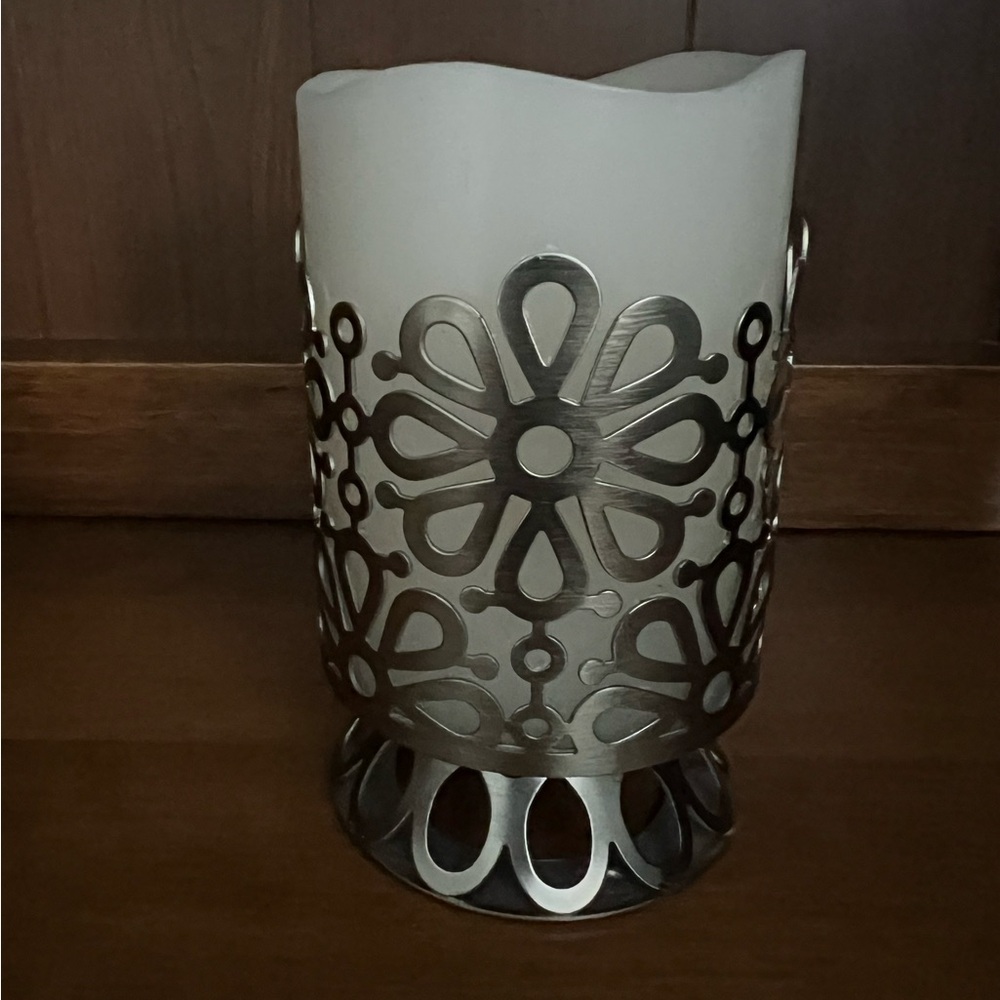 Floral silver color metal footed candle holder with battery operated candle.